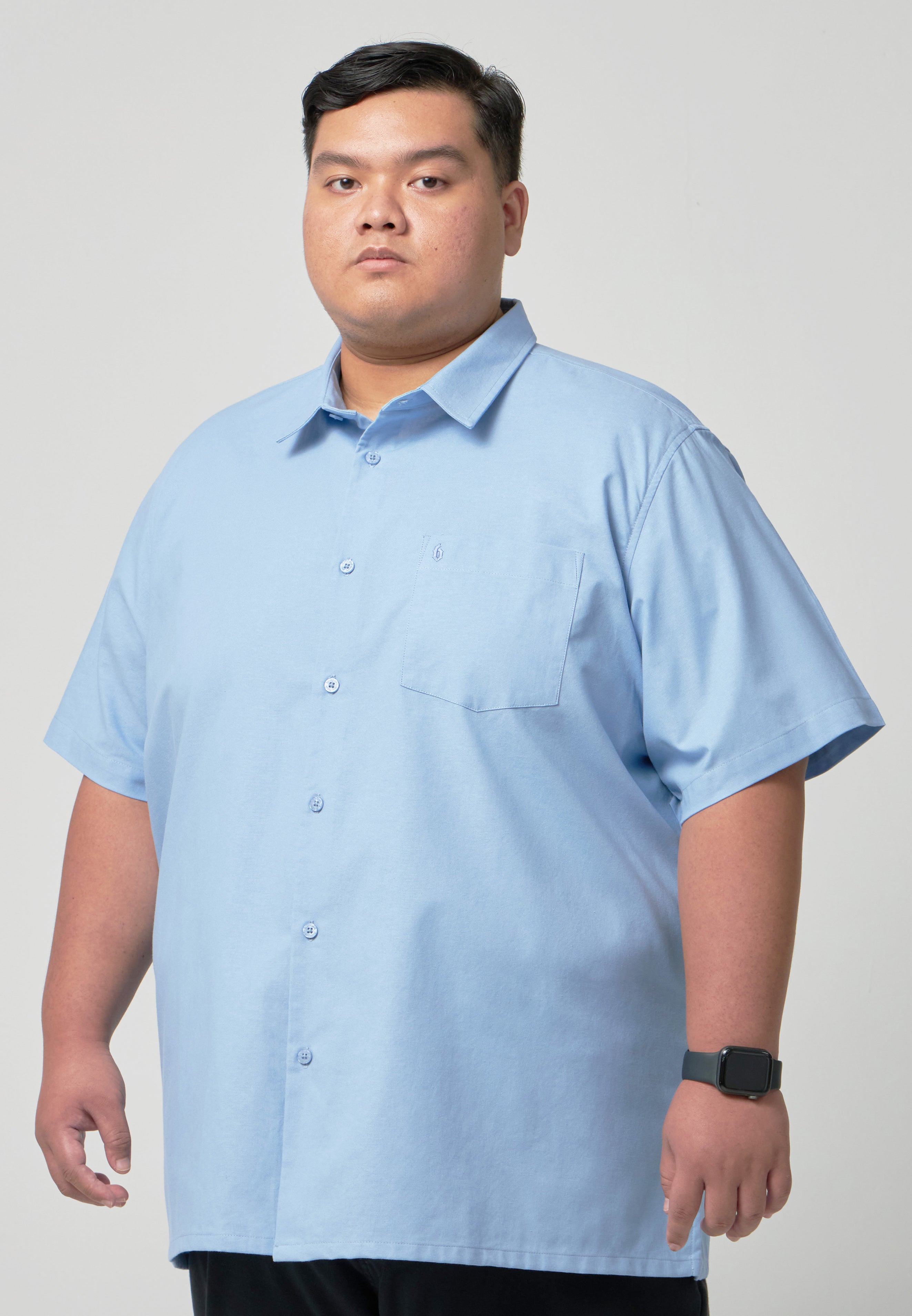 A plus-size male model wearing a plus-size shirt named Alex Shirt made from Oxford Cotton in sky blue color #color_Sky Blue